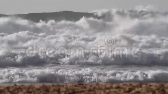 阳光明媚的一天海浪涌向沙滩视频的预览图