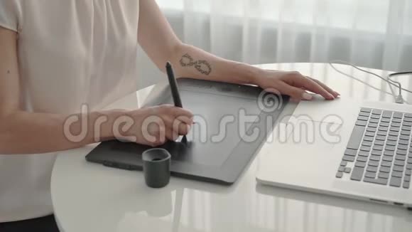 女设计师画一个图形平板在家拿着笔记本电脑工作的女人视频的预览图