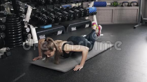 在健身房做俯卧撑的年轻女人视频的预览图