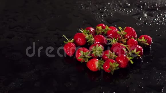 在潮湿的黑色表面上特写草莓视频的预览图