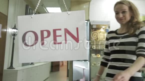 开放式标志在店面窗口中被关闭女人打开铭牌视频的预览图