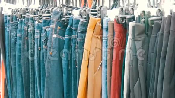 裤子挂在衣架上女人看衣服选择跳蚤市场市场上出售的衣服视频的预览图