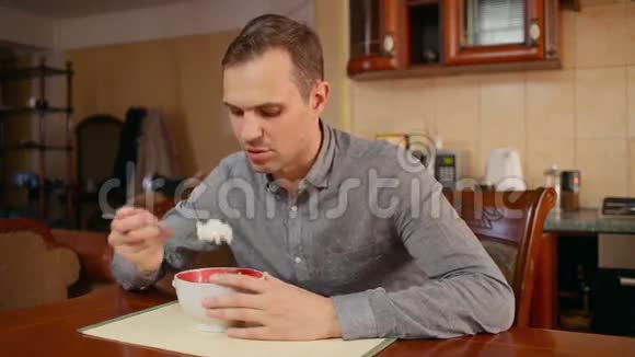 男人在家里的厨房里吃米饭和肉视频的预览图