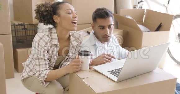 年轻的混血情侣用笔记本电脑视频的预览图