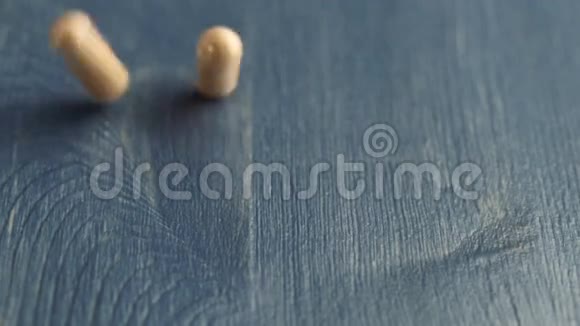 药片胶囊掉落在蓝桌柜台上视频的预览图