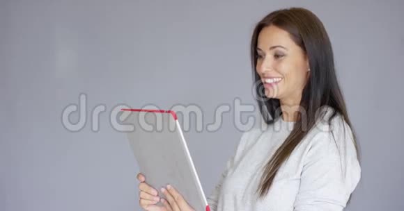快乐微笑的黑发女人视频聊天平板电脑视频的预览图