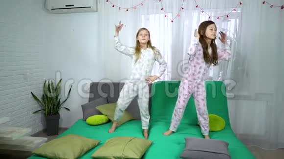 两个穿睡衣的可爱女孩在沙发上跳舞视频的预览图