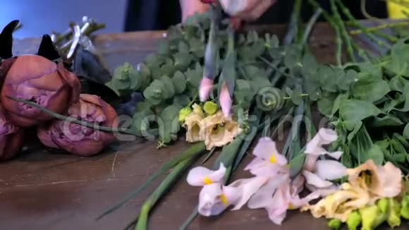 花商妇女在花店里做花束棕色牡丹和虹膜视频的预览图