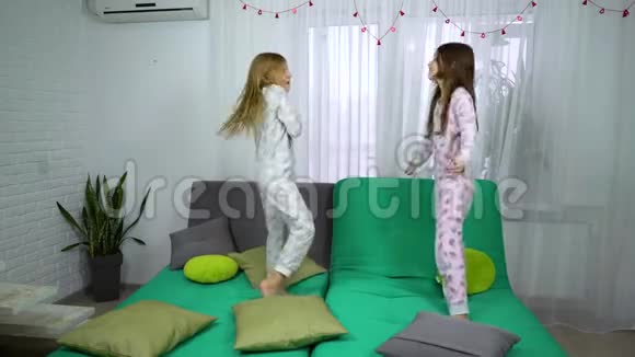 两个穿睡衣的女孩在沙发上跳舞视频的预览图