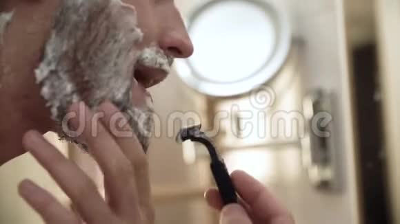 男人面对头发护理男性剃须刀与剃须刀特写视频的预览图