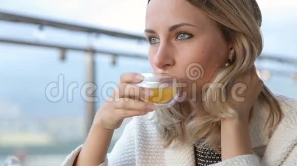 美丽快乐的年轻女子早上在咖啡馆喝茶视频的预览图