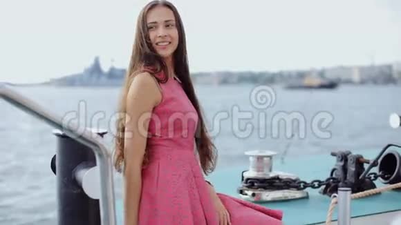 一个漂亮的女孩留着长发穿着裙子站在船上视频的预览图