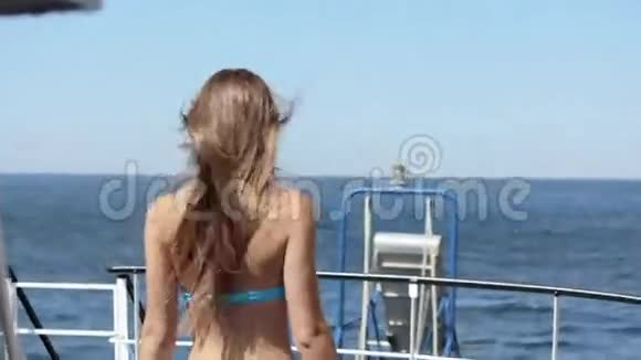 穿比基尼的漂亮模特背着她站在船上视频的预览图