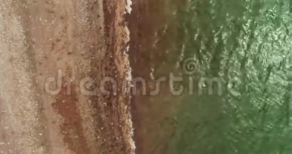 空中镜头拍摄一个湖滩和一个戴帽子的女孩视频的预览图