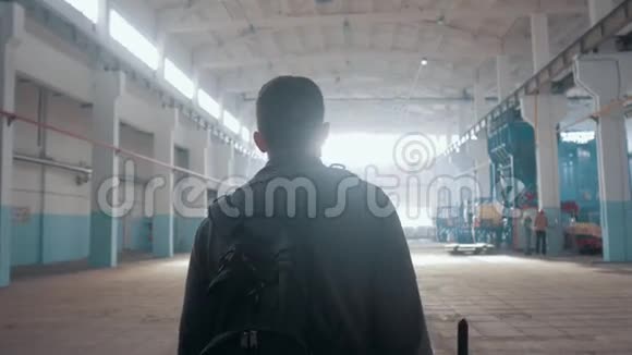 男经理男子走在大的现代仓库背对着观众视频的预览图