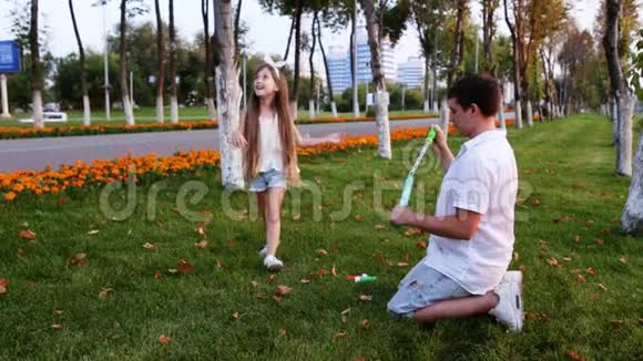 小女孩在草坪上吹肥皂泡视频的预览图