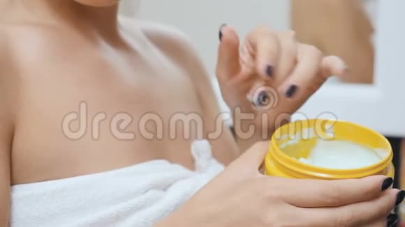 女性用奶油滋润她的皮肤视频的预览图