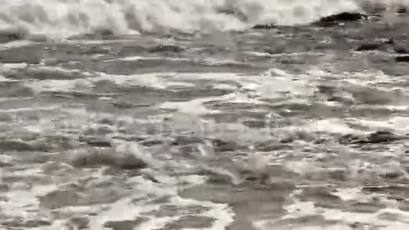 海浪冲刷着岩石和泥滩视频的预览图