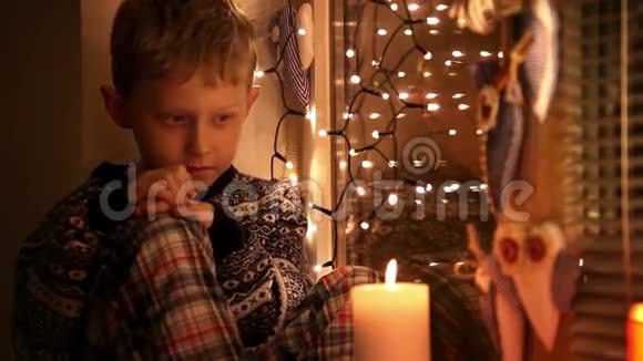 悲伤的小男孩穿着睡衣和冬装毛衣等着圣诞老人视频的预览图