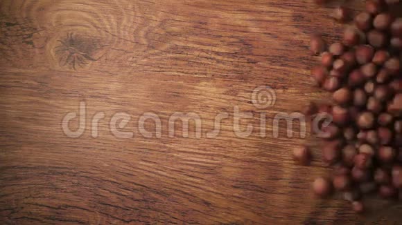 慢动作榛子壳在木桌上滚动视频的预览图