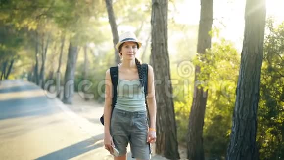 美丽的森林漫步时迷人的旅游女孩微笑着看着镜头视频的预览图