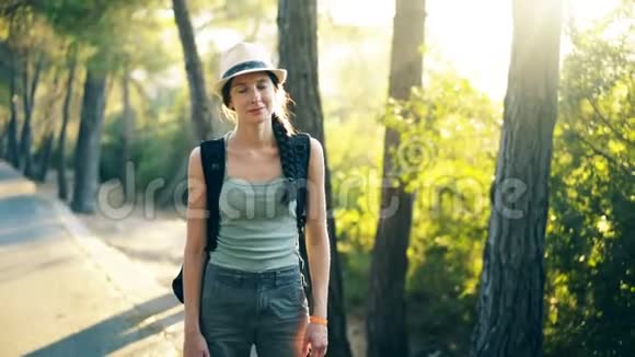 美丽的森林漫步时迷人的旅游女孩微笑着看着镜头视频的预览图