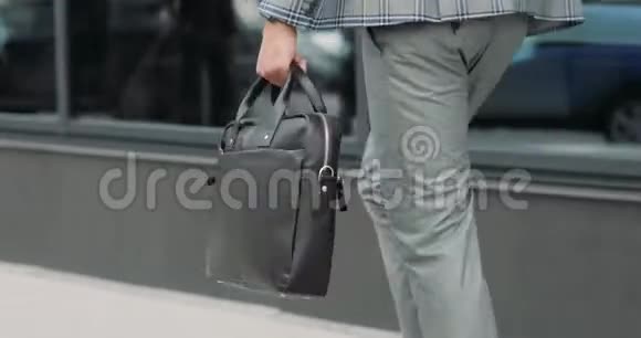商务人员带着公文包走在商业区的街道上视频的预览图