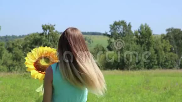 少女在绿草上旋转抱着向日葵视频的预览图