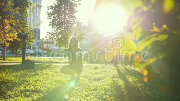 年轻的妈妈和小儿子一起在日落时的夏日公园玩慢动作视频的预览图