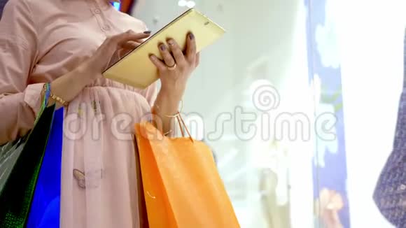 女人用平板电脑计划在商场购物视频的预览图