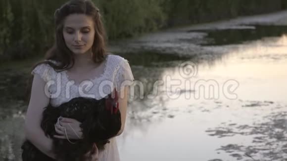 穿着白衣服的布鲁内特和她在河边的公鸡视频的预览图