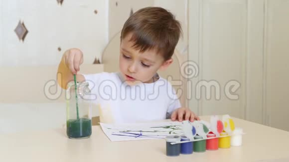 幼儿在一张白纸上画水彩画坐在桌旁视频的预览图