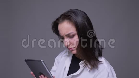 在带有背景的相机前在平板电脑上特写一一幅有吸引力的白种人成年女性视频的预览图