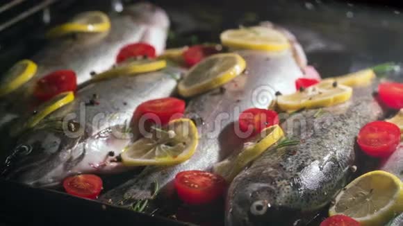 美味的鳟鱼在烤箱里用柠檬西红柿和香料烘烤视频的预览图