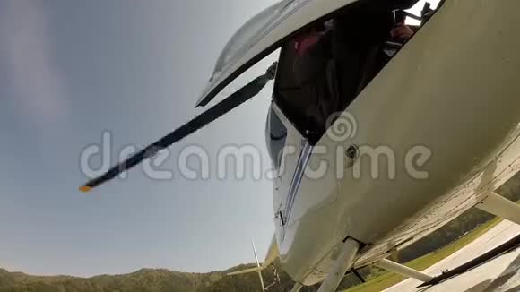 直升机正准备起飞飞行员关上了门小型轻型航空螺旋桨的底部视图视频的预览图