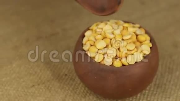 用勺子把旋转的泥锅里的豌豆粒倒掉视频的预览图