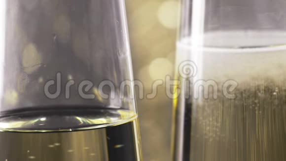 在金色bokeh背景下用金色气泡填充香槟长笛的特写镜头黄金豪华假日的概念视频的预览图
