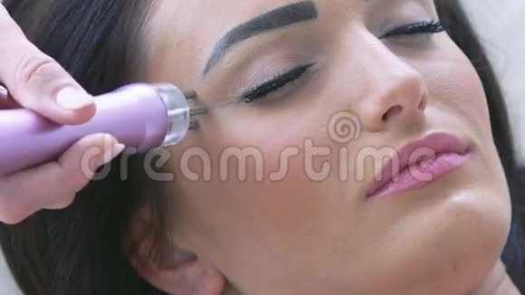 闭合年轻女性头部接受电超声面部按摩视频的预览图
