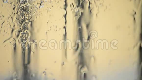 下雨时雨水在玻璃窗滑落视频的预览图