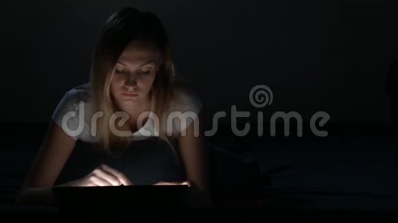 可爱的女孩在睡觉前使用数字平板电脑视频的预览图