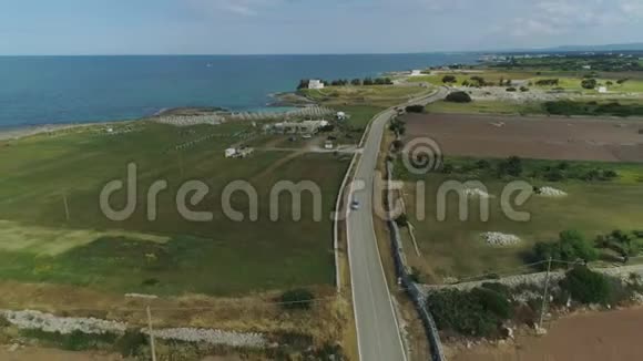 在意大利无人驾驶飞机4k飞行中汽车穿过靠近大海的田野视频的预览图