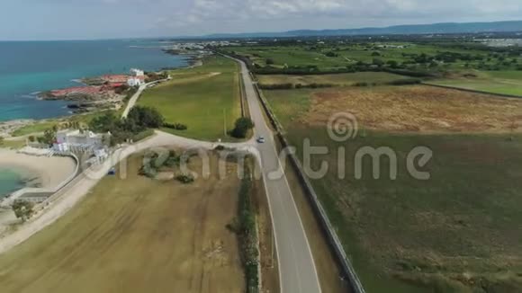 在意大利无人驾驶飞机4k飞行中汽车穿过靠近大海的田野视频的预览图