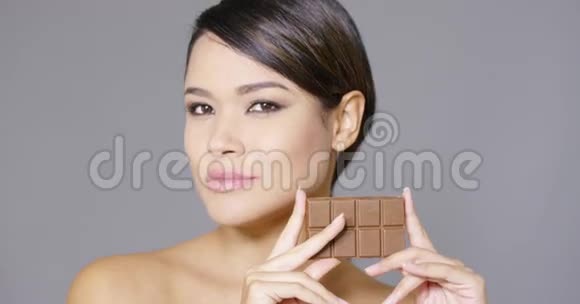 美丽微笑的女人拿着巧克力视频的预览图