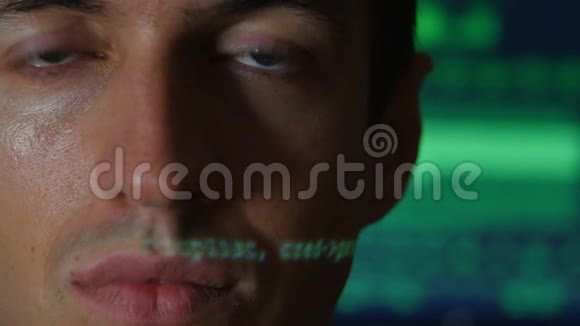 带有绿色代码字符的人程序员黑客画像在他脸上反射电脑屏幕上显示视频的预览图