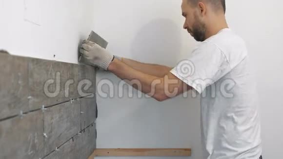 家居装修装修施工工人用瓷砖瓷砖墙面粘合剂砂浆勾缝视频的预览图