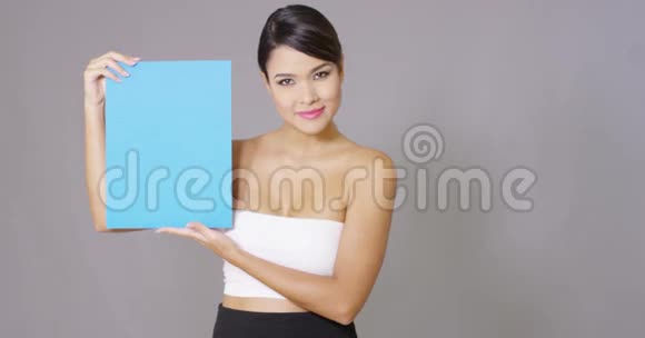年轻漂亮的女人指着一块空白的牌子视频的预览图