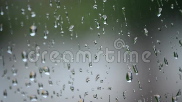 雨滴在下雨的时候从窗户玻璃滑落视频的预览图