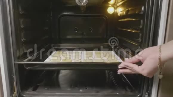 烤盘上的碎饼干从烤箱里热出来女人拿着饼干托盘和自制的饼干烤视频的预览图