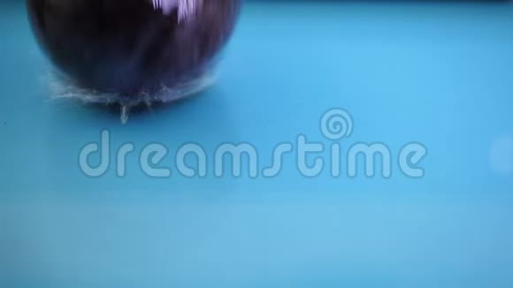 李子在蓝色背景下溅入水中视频的预览图