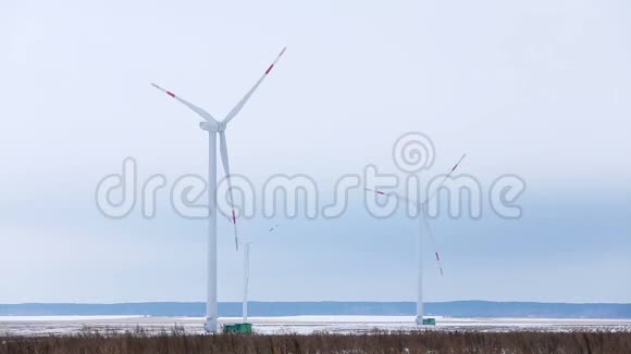 在雪域远处旋转风力涡轮机视频的预览图